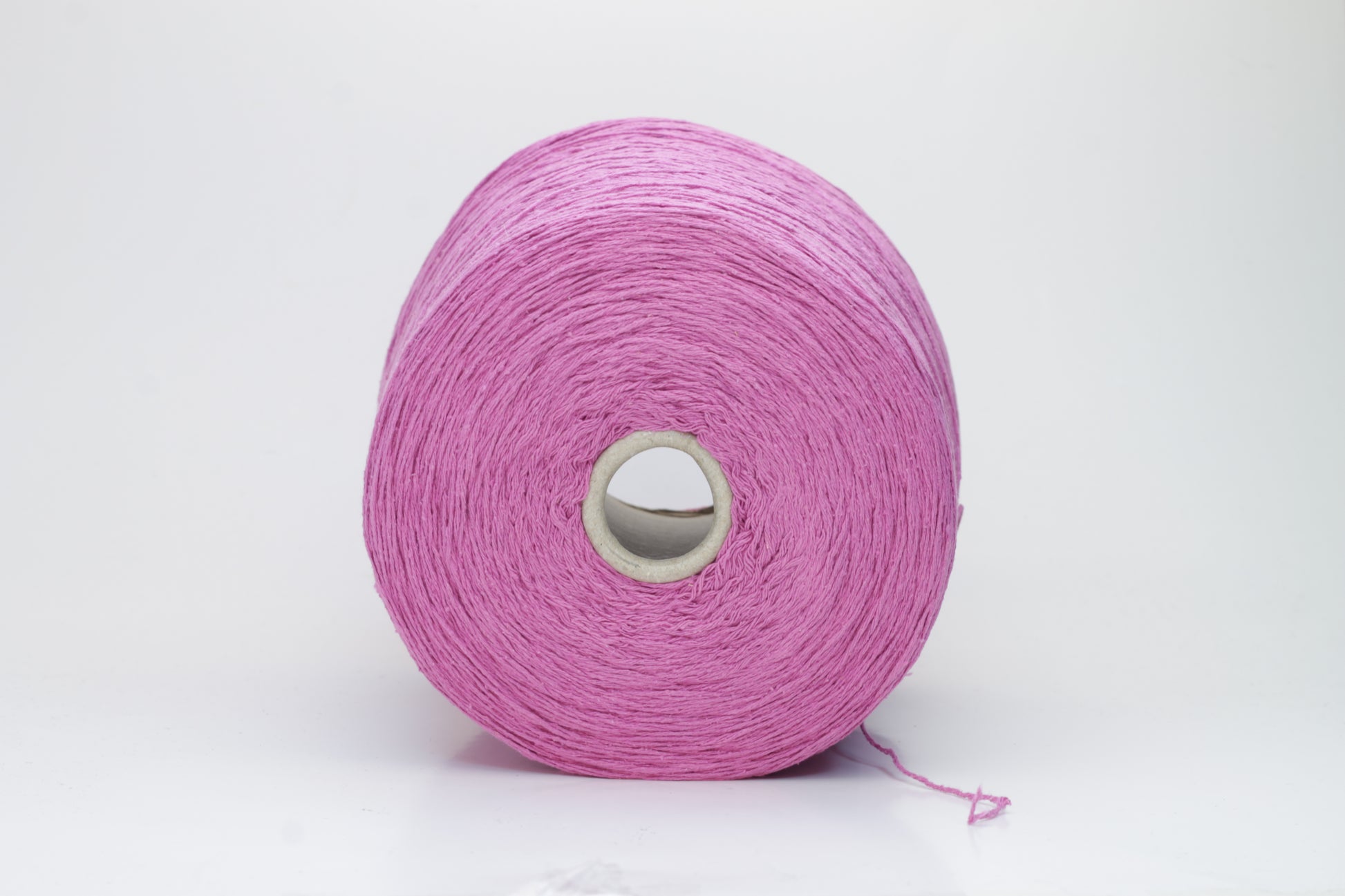 Close-up shot of the Rosa Fuxia Silk Bourette yarn, showcasing its shimmering, fluffy texture and tightly twisted ply structure. The silk fibers exhibit a subtle sheen with rich color depth.