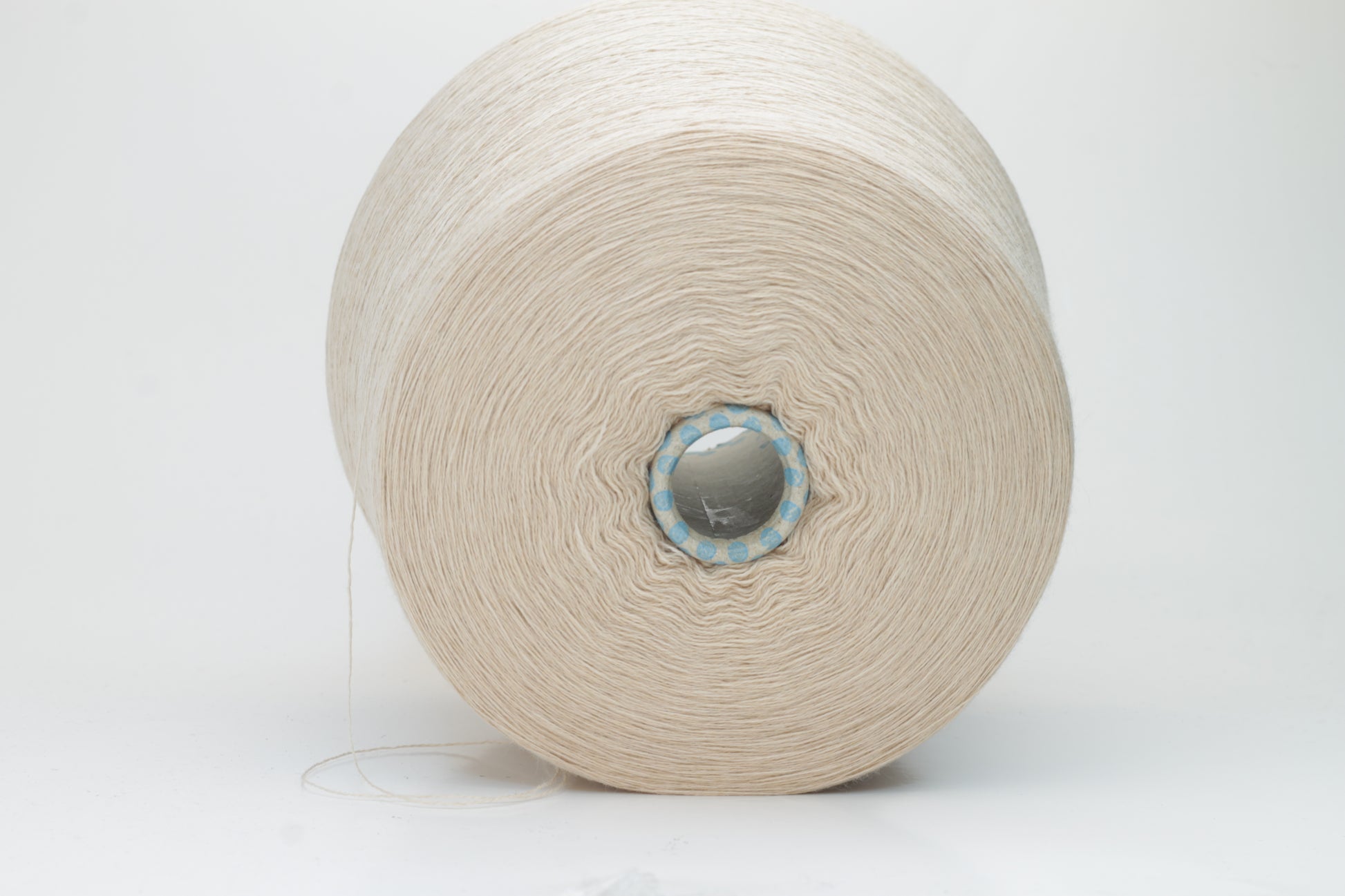 Close-up shot of creamy beige merino yarn, featuring a tight ply twist and a subtle sheen. The fibers exhibit exceptional fluffiness and texture, ideal for intricate knitting patterns.