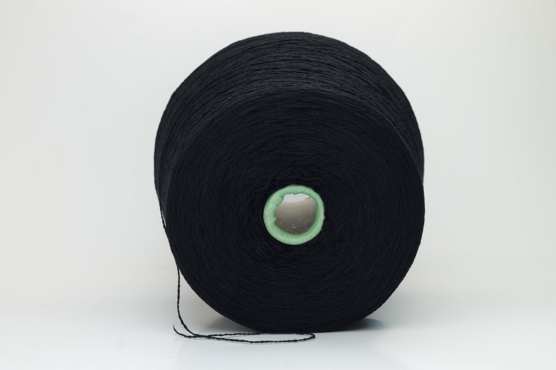 Luxurious black cashmere yarn, two-ply twist with a subtle sheen, displaying deep, consistent color and a fine, soft texture ready for crafting.