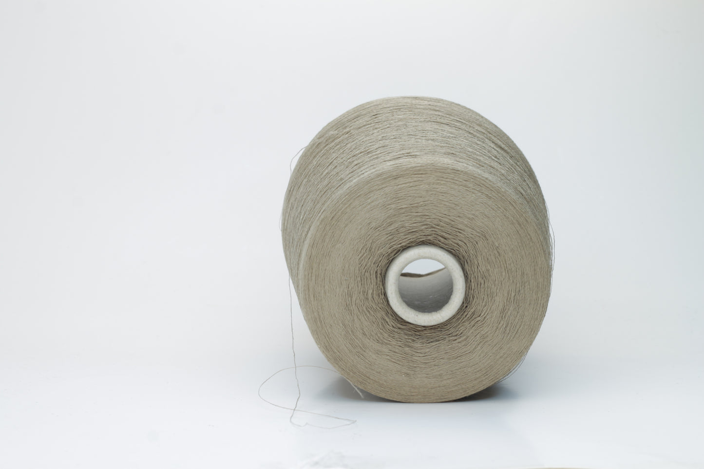 A skein of natural, undyed linen-polyamide yarn in an earthy beige. Features fine, even strands with a subtle organic texture and gentle luster.