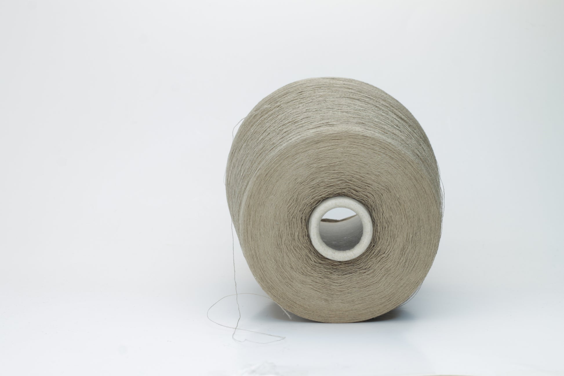 A skein of natural, undyed linen-polyamide yarn in an earthy beige. Features fine, even strands with a subtle organic texture and gentle luster.