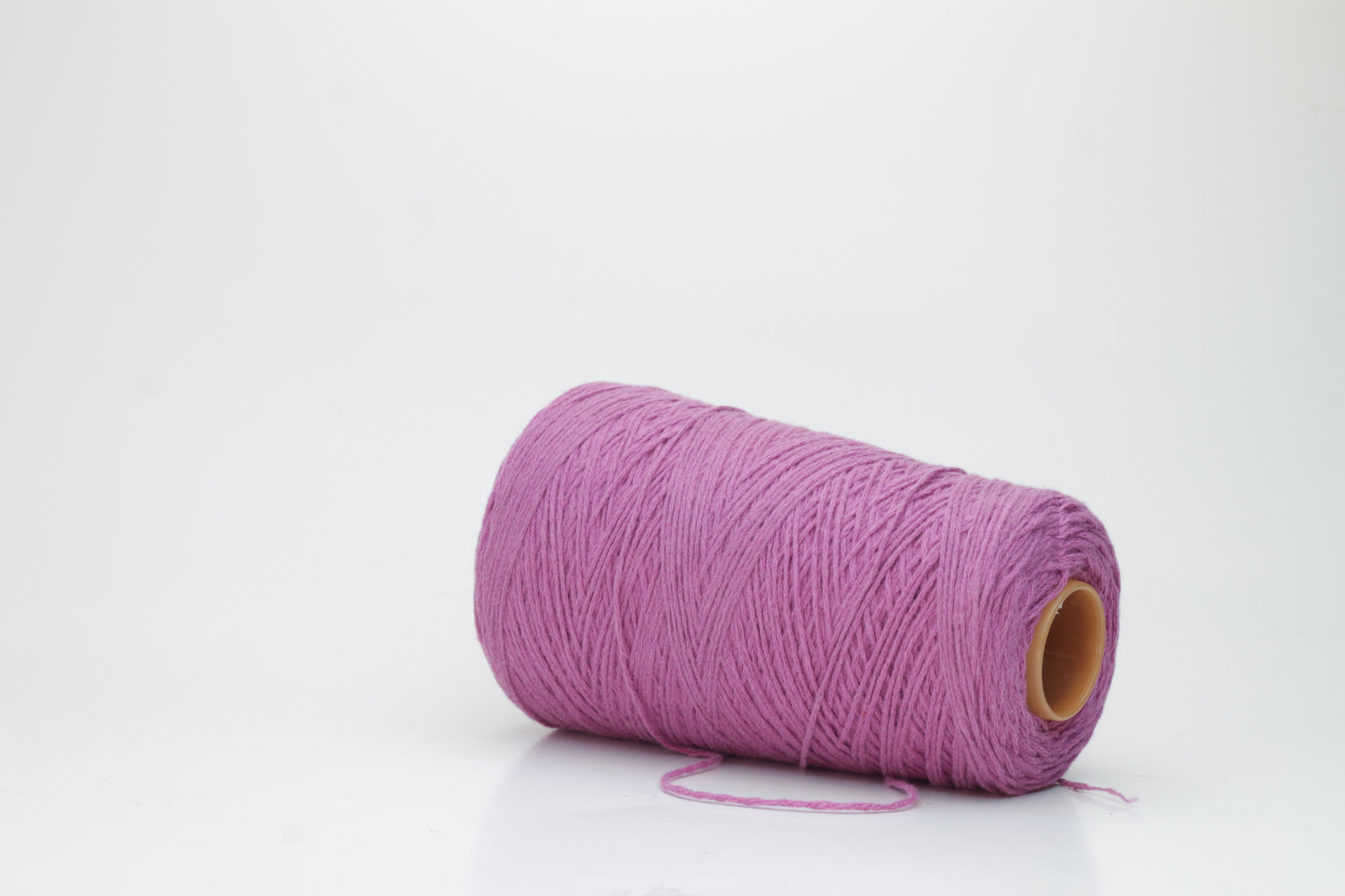 A beautifully wound cone of fine, single-ply cashmere yarn in a soft wisteria purple hue, displaying a delicate halo of fluff and subtle sheen.