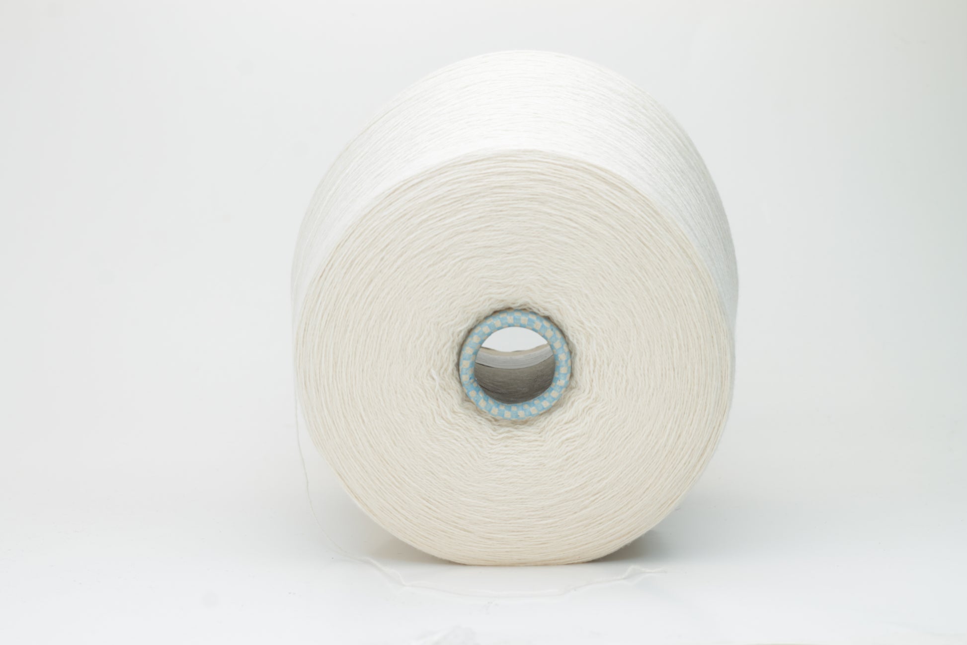 Close-up of a finely spun, 2-ply cashmere yarn skein in a delicate, warm champagne beige. Features a soft, subtle napped texture and elegant sheen.