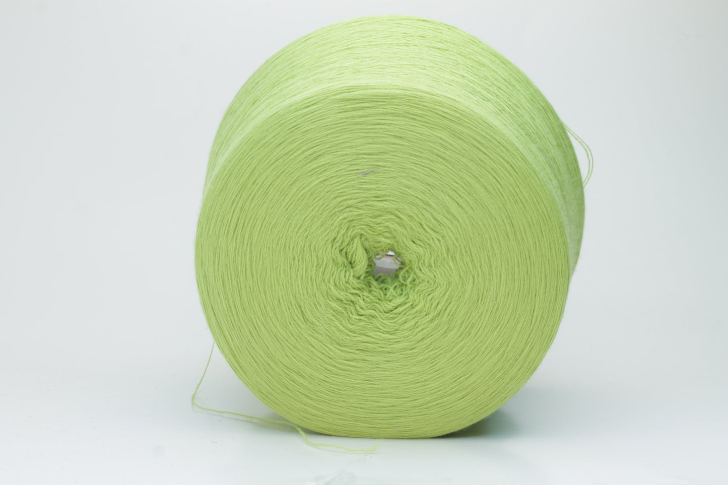 Close-up shot of the '100% Merino Toolegno 1900 Nm 2/30 Green Premium Yarn', showcasing the fluffy green fibers and a prominent ply twist, highlighting the dense thread structure and subtle sheen.
