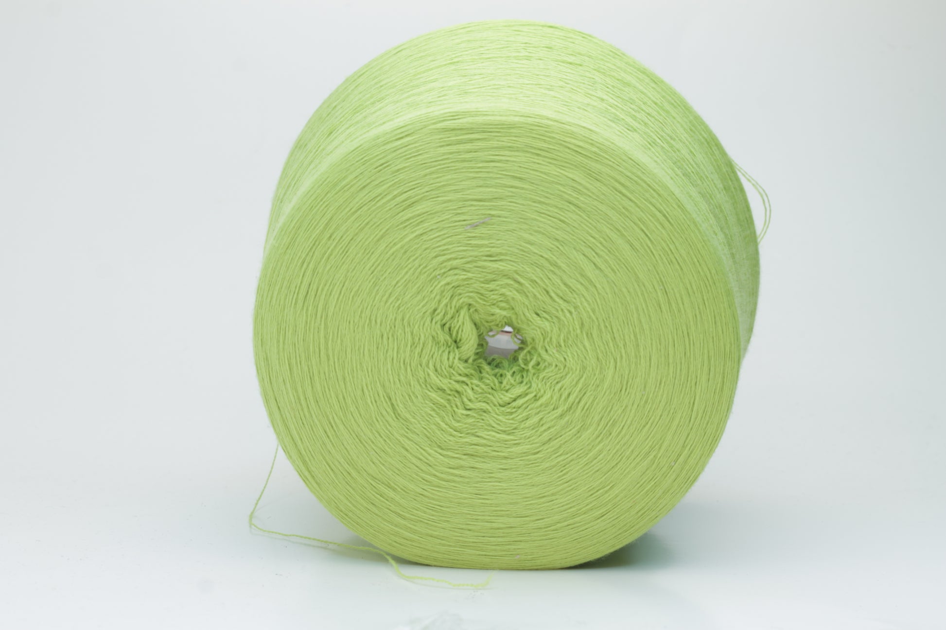 Close-up shot of the '100% Merino Toolegno 1900 Nm 2/30 Green Premium Yarn', showcasing the fluffy green fibers and a prominent ply twist, highlighting the dense thread structure and subtle sheen.