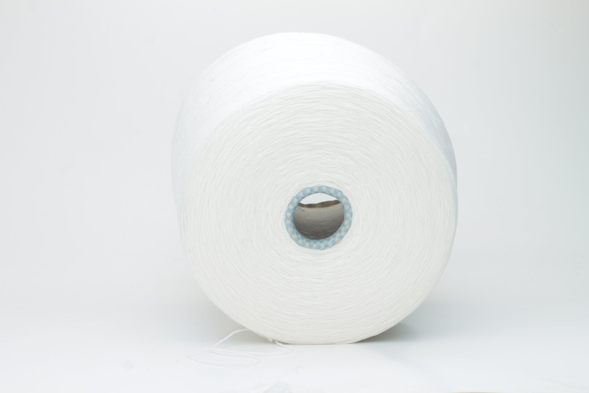 Close-up of a luxurious, soft skein of pale, milky blue cashmere yarn with a subtle sheen and light, even two-ply twist.
