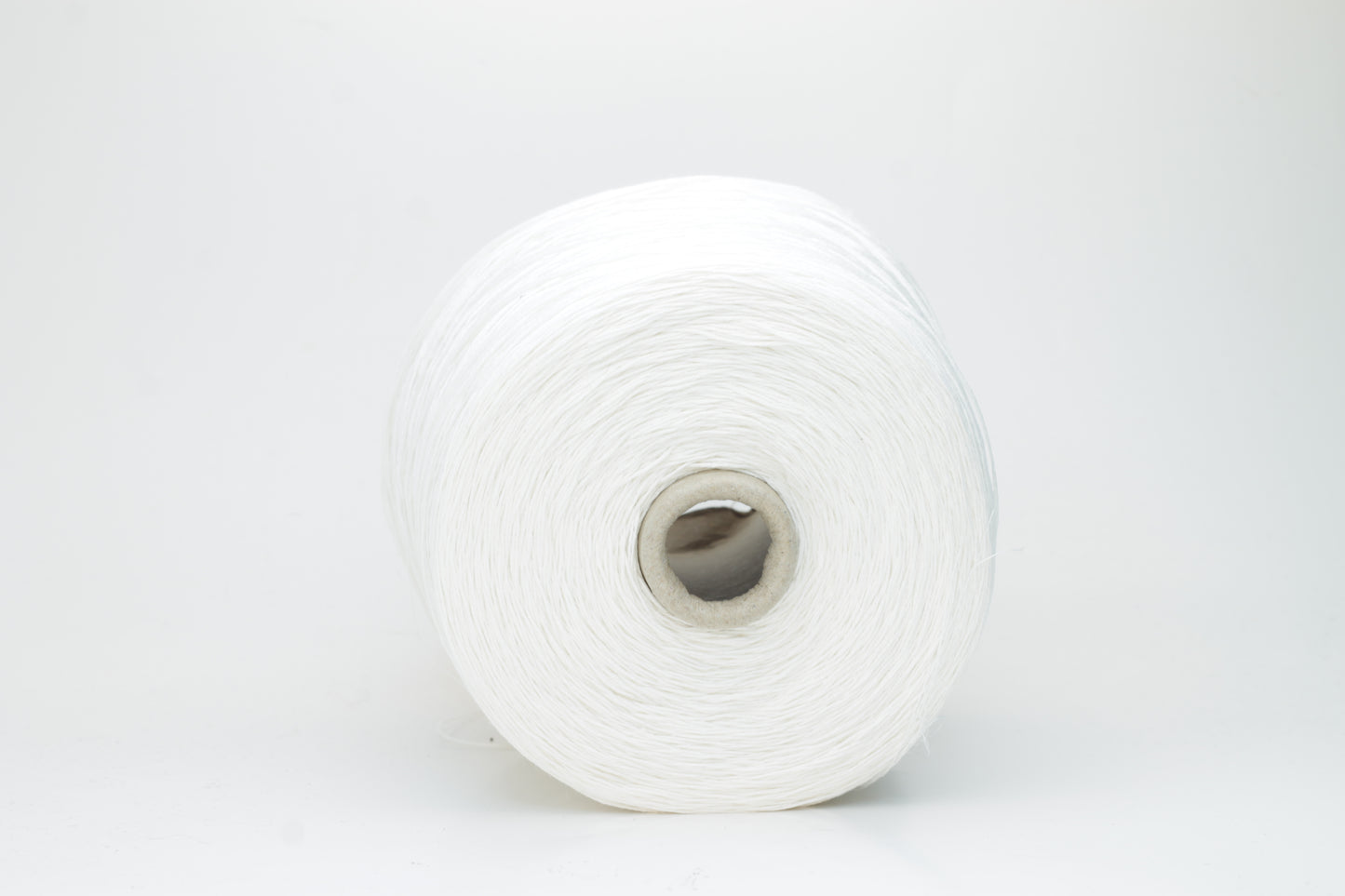 Close-up of pristine white linen and viscose blend yarn, softly twisted with a subtle sheen, showcasing its fine, smooth texture.