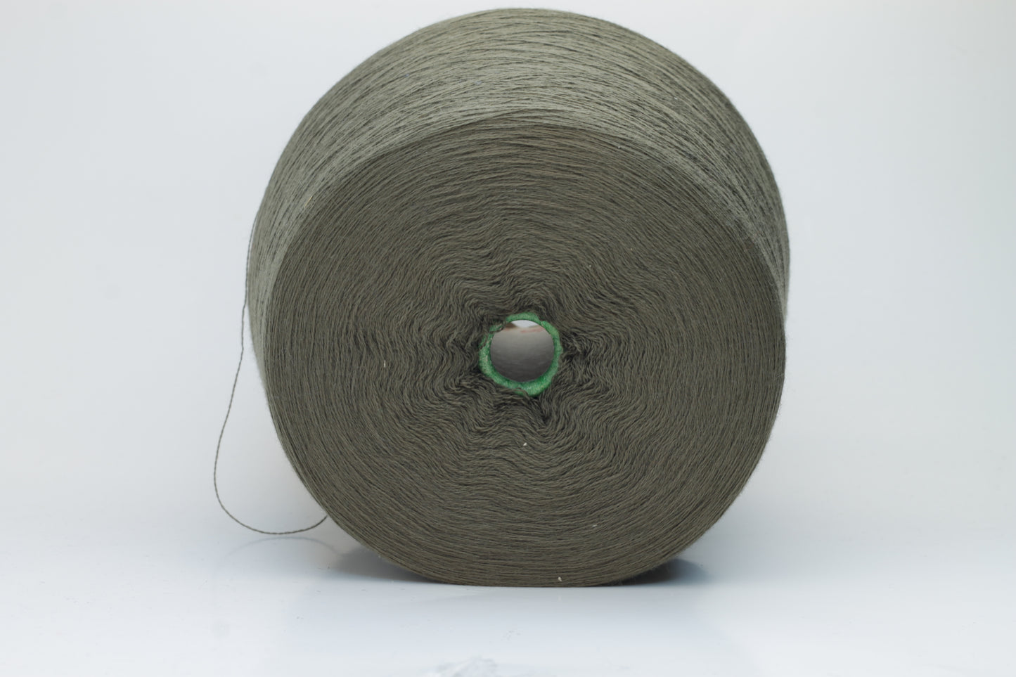 Close-up shot of a vibrant green Merino 100% Cashwool yarn skein. The yarn features a tight, dense ply twist and a subtle sheen, with visible individual strands creating a rich, textured effect.