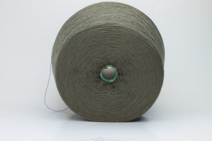 Close-up shot of a vibrant green Merino 100% Cashwool yarn skein. The yarn features a tight, dense ply twist and a subtle sheen, with visible individual strands creating a rich, textured effect.