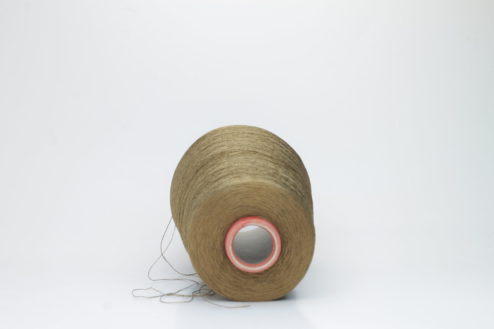 Close-up of a spool of finely twisted, single-ply Organzino silk yarn in a deep, lustrous bronze hue, catching light with a subtle, elegant sheen.