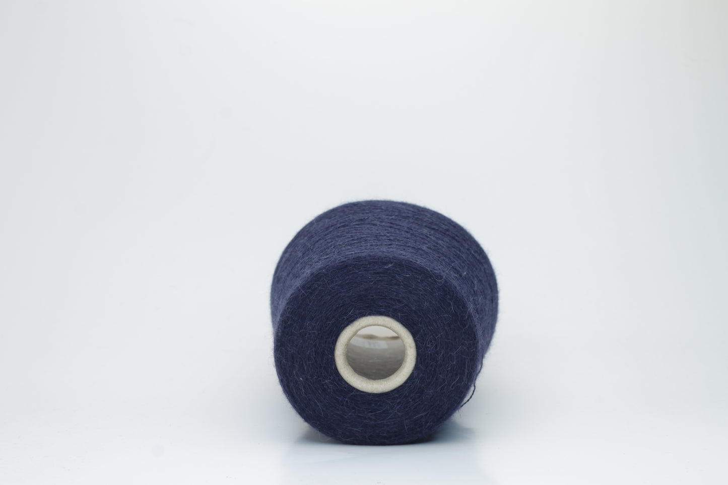 Close-up of Quipa Nm 2/28 Alpaca Merino yarn, showing its soft, slightly diffused fibers and a tight, even two-ply twist in a rich, dark navy hue.