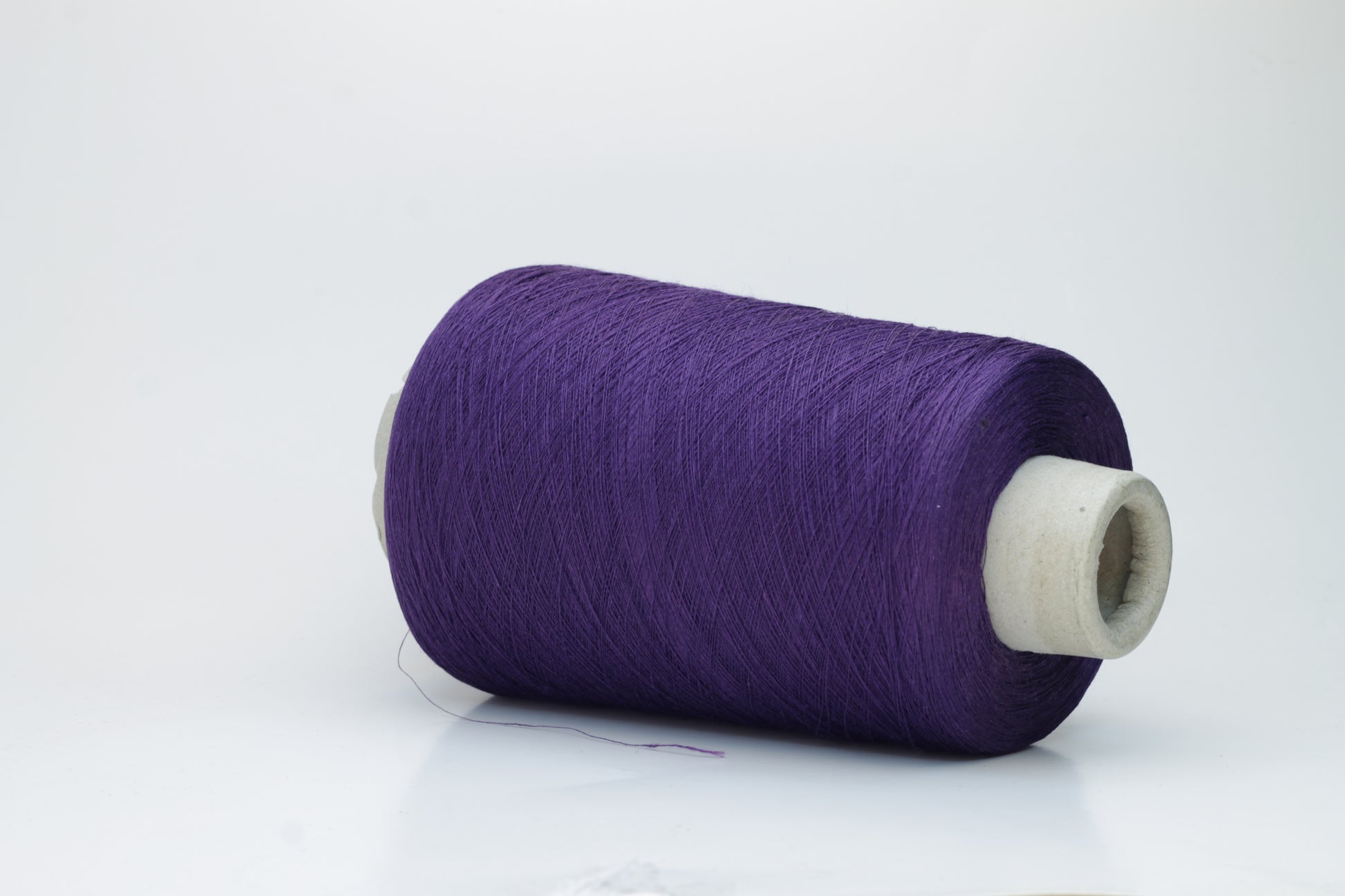 Rich, deep purple yarn wound into a soft, slightly textured skein, exhibiting a subtle natural sheen from its linen content and a smooth, even twist.