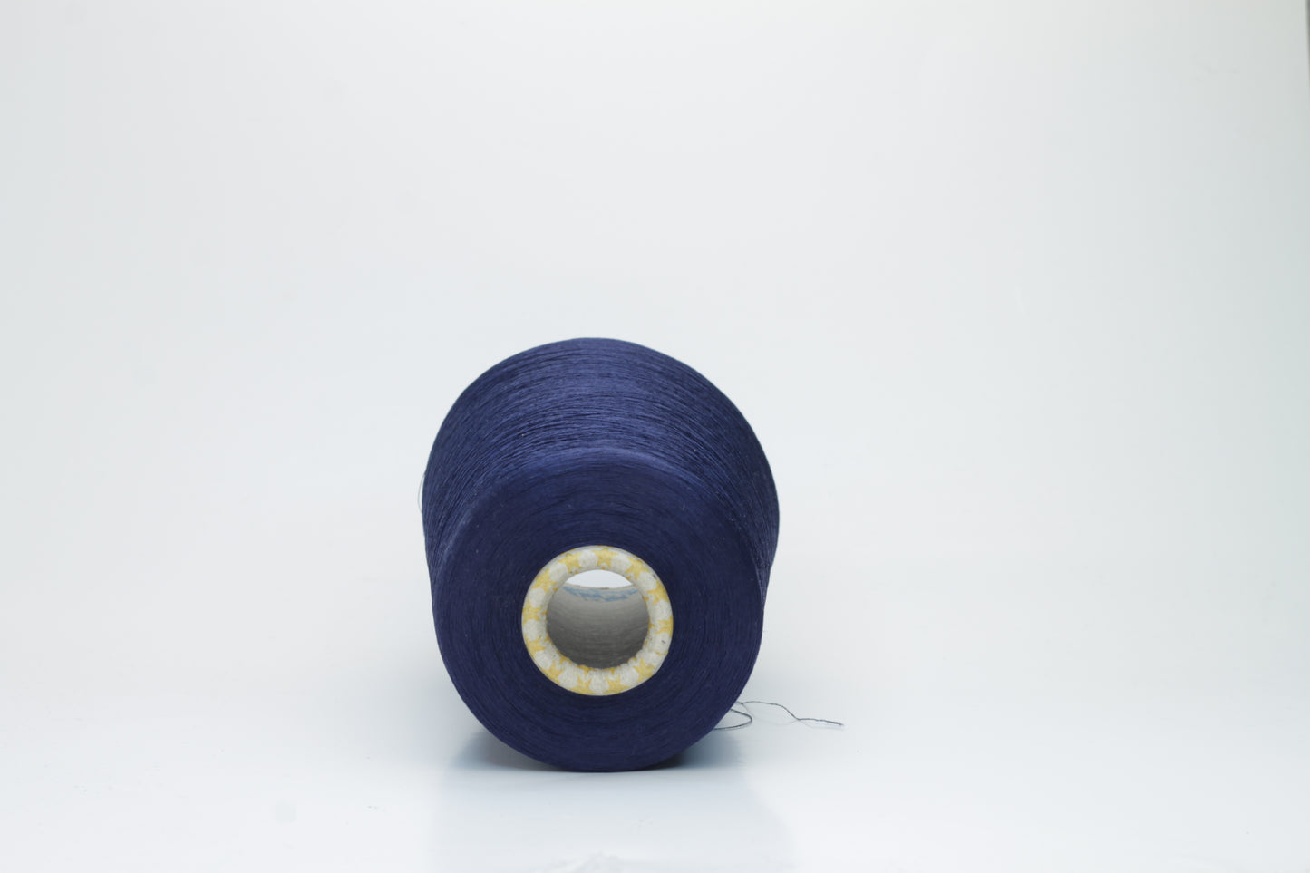 Close-up of finely spun navy blue silk yarn, gently twisted, displaying a subtle, elegant sheen. Smooth, lustrous fibers reflect light softly, hinting at fluid drape and rich color depth.
