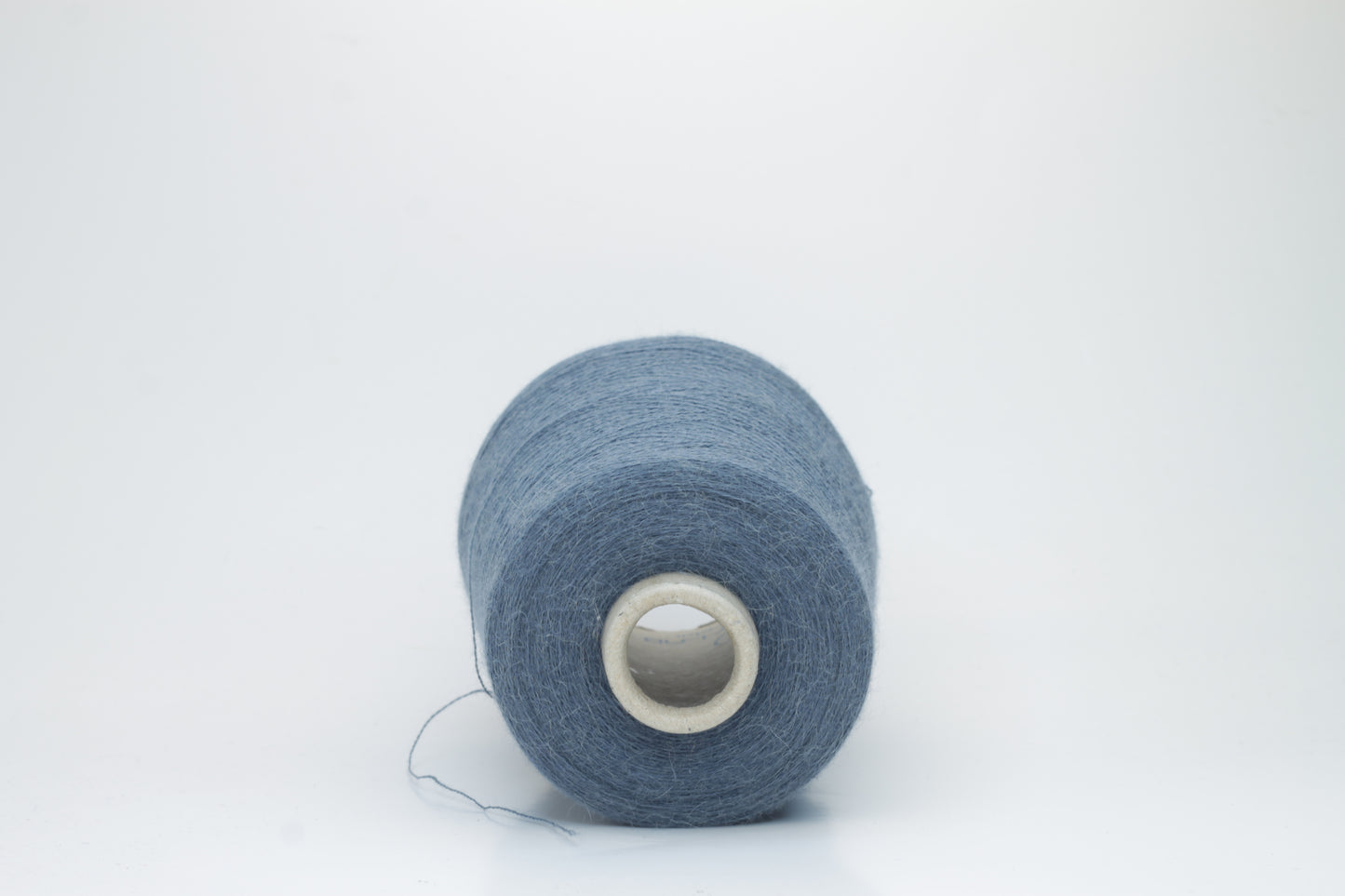 Close-up of a skein of soft, plied alpaca merino yarn in a deep Blue, showing subtle sheen and fine fiber halo.