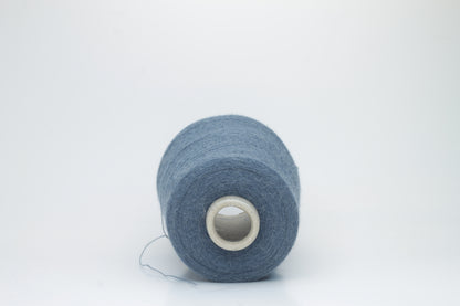 Close-up of a skein of soft, plied alpaca merino yarn in a deep Blue, showing subtle sheen and fine fiber halo.