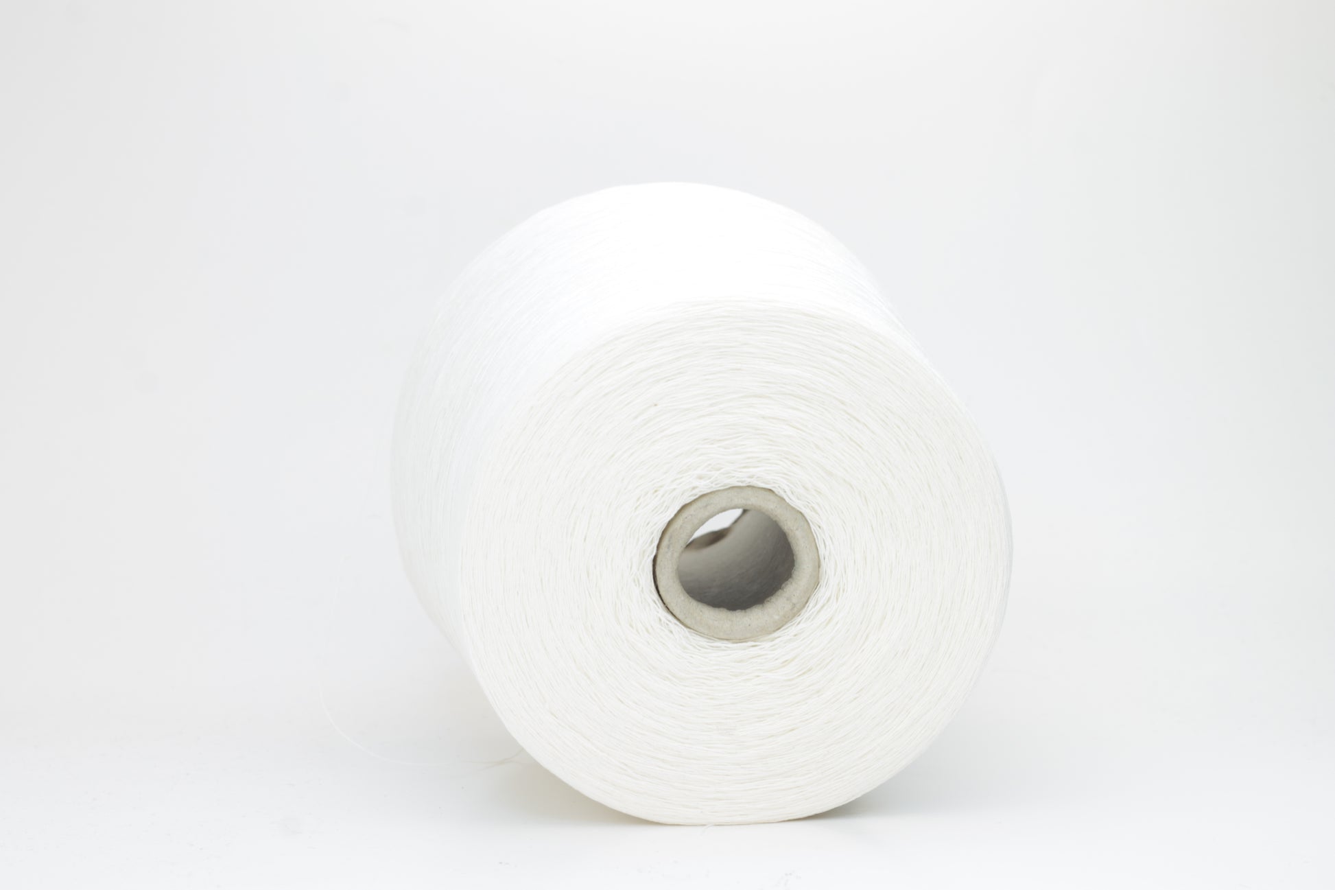 A soft white three-ply linen yarn, tightly twisted with a subtle natural sheen, presented in a neatly wound skein, showcasing its crisp, cool texture.