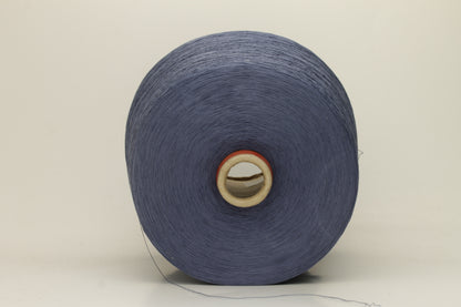 A tightly spun two-ply thread of very fine silk, exhibiting a deep, rich indigo blue hue with a natural, subtle shimmer under light.