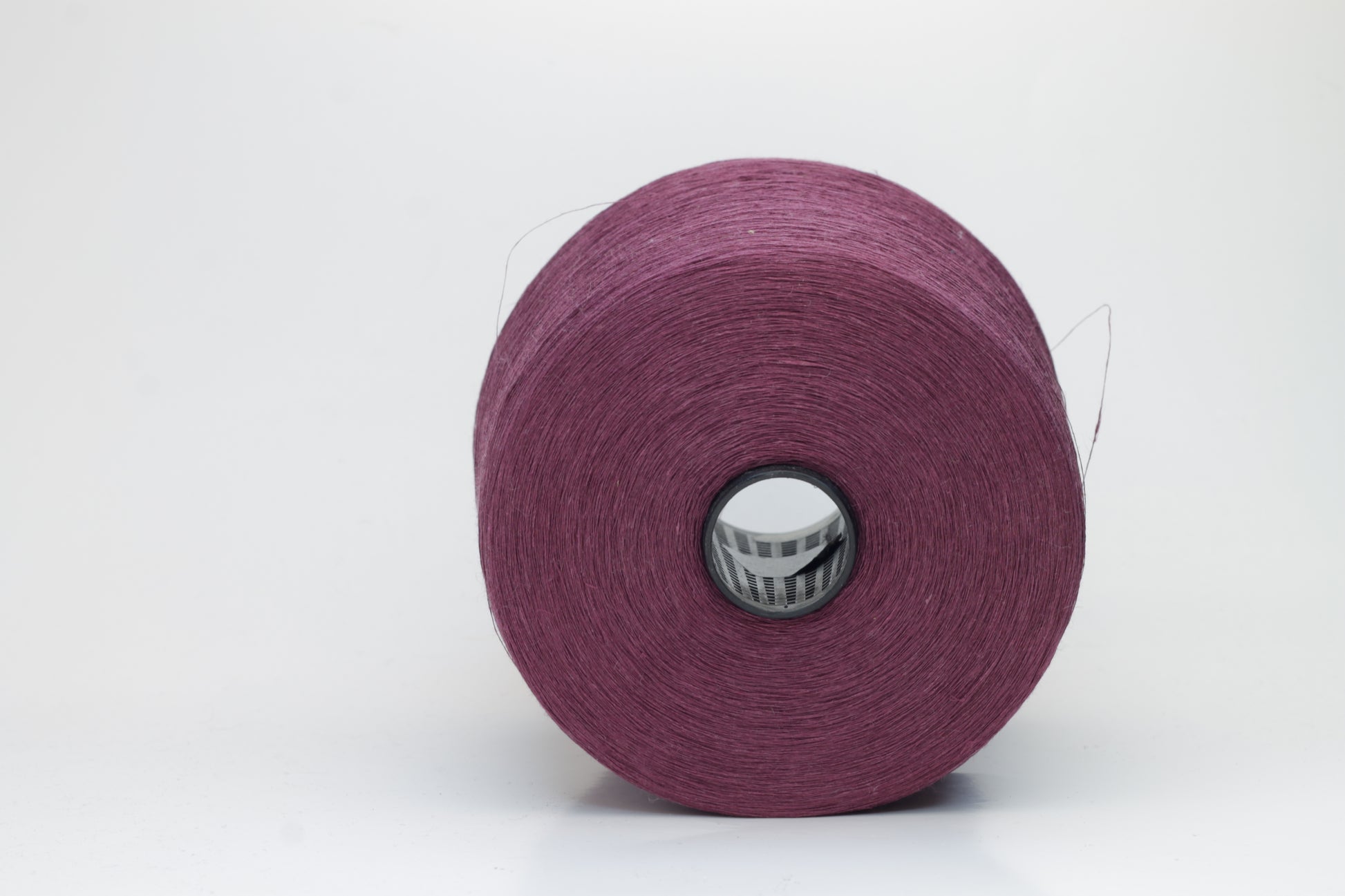 Fine, single-ply linen yarn in a Cardinal. Reveals a crisp texture and subtle natural sheen, typical of pure linen fiber.