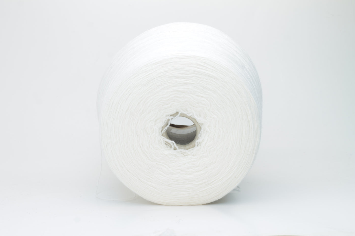 Close-up of a pure white cashmere yarn skein, showcasing its soft, slightly fluffy texture and subtle sheen with a gently twisted, fine two-ply structure.