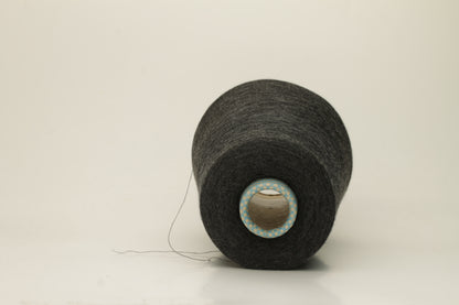 Close-up of a luxurious, finely spun two-ply cashmere silk blend yarn in a soft, elegant gray shade with a subtle sheen, showcasing its delicate texture.