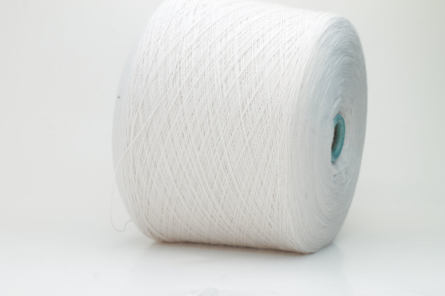 Close-up shot of creamy white Zegna Baruffa merino yarn, showcasing a dense, twisted ply structure and subtle sheen, with a fluffy texture inviting tactile exploration.
