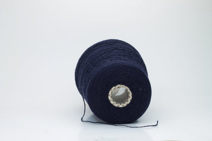 A tightly spun two-ply yarn, rich navy blue, made from exceptionally soft, fine cashmere fibers with a slight halo, presented as a graceful hank.