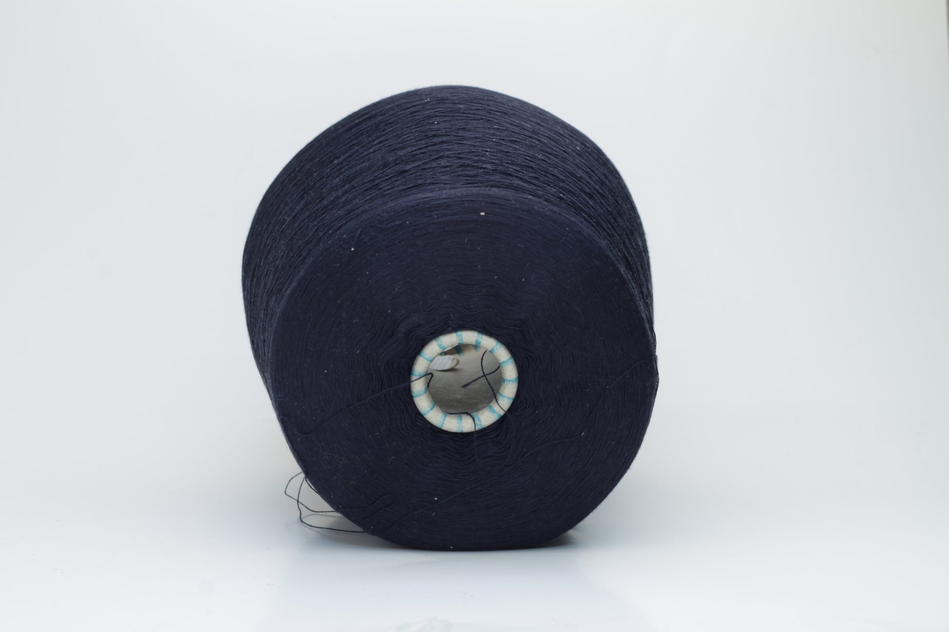 A gleaming skein of fine-gauge, two-ply silk yarn, deep rich dark navy hue, showcasing smooth texture & luxurious natural sheen.