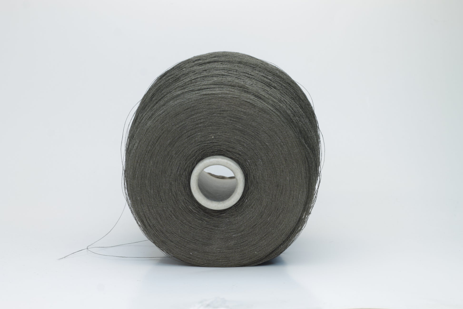 Skein of finely spun yarn, a muted artichoke green. Its smooth, even twist reveals the crisp texture of linen with a subtle, natural sheen. Low fluff, clean look.