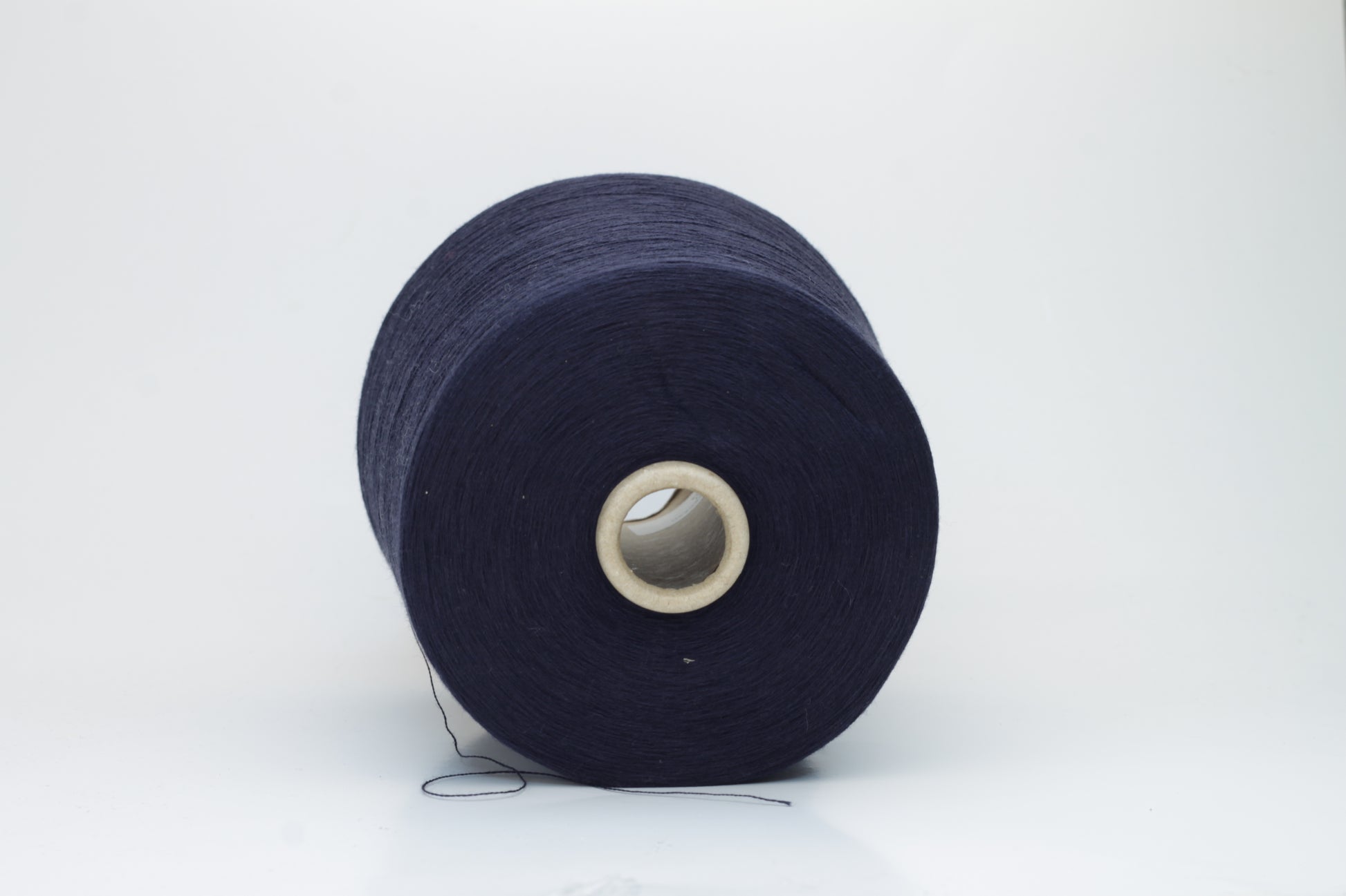 Close-up shot of dark blue, fluffy cotton 85% cashmere 15% yarn in a twisted ply, showcasing the fine thread structure and subtle sheen.