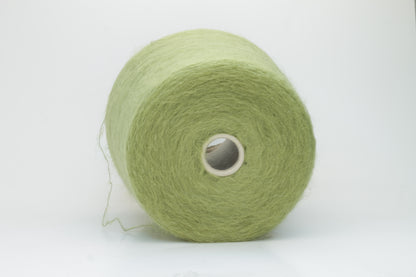 Close-up shot of vibrant green SuperKidMohair yarn showcasing a tight ply twist and rich fiber structure, revealing its inherent fluffiness and subtle sheen.
