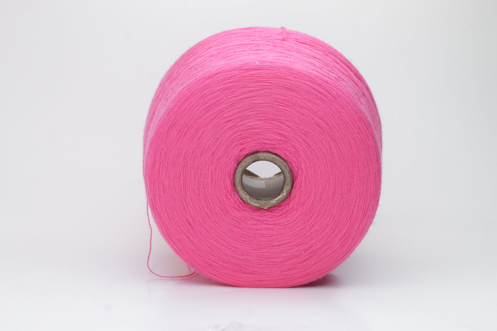 Close-up view of vibrant hot pink Zegna Baruffa Merino Cashwool yarn, showcasing its smooth, twisted ply structure and rich color depth.