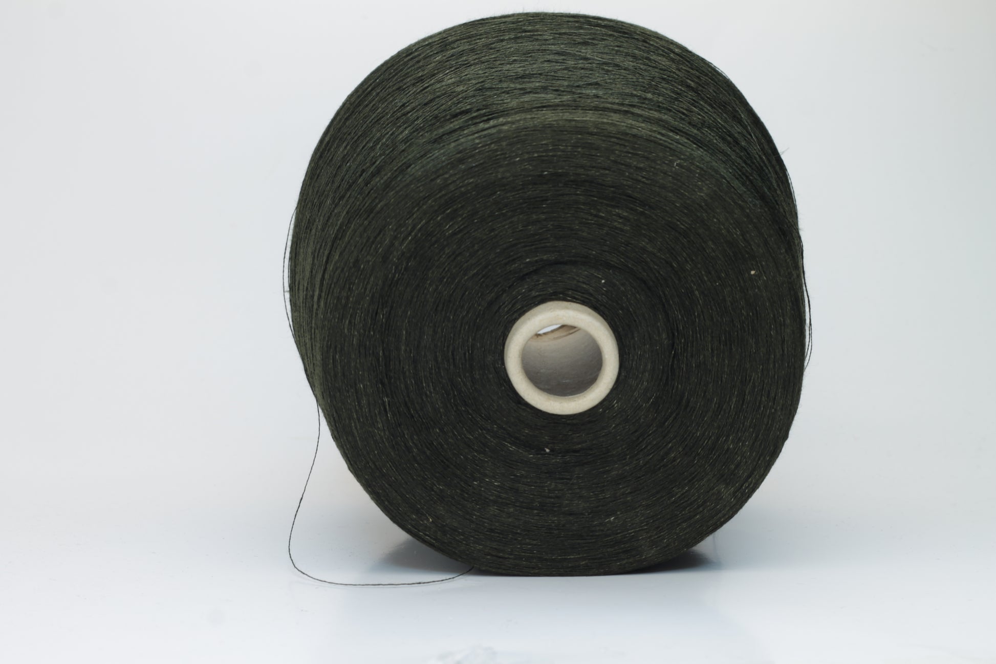 Two plies of earthy Cicoria brown linen yarn, tightly twisted with visible fibers, showcasing natural slubs and a subtle, sophisticated sheen.