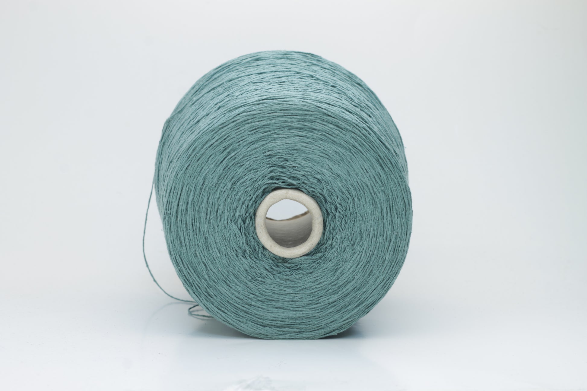 Close-up shot of shimmering silk bourette yarn in a rich verdone color. The multi-plied strands show subtle twist and depth, with a delicate sheen and fluffy texture.