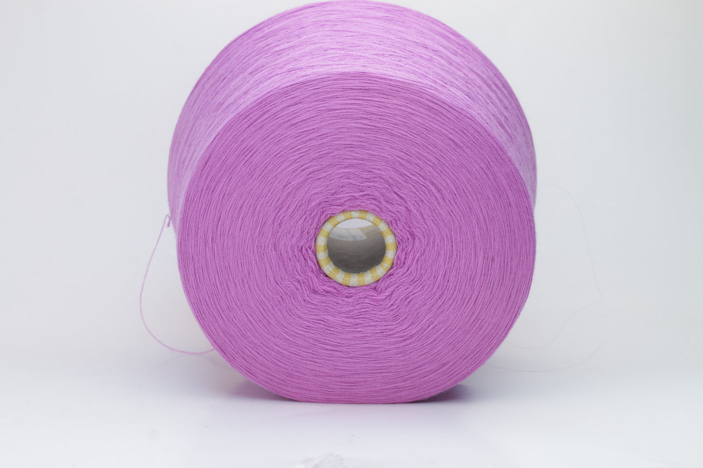 Close-up image showcasing a vibrant purple 100% merino yarn skein with a slight twist, revealing the fine ply structure and rich color depth; the fiber appears fluffy and soft.
