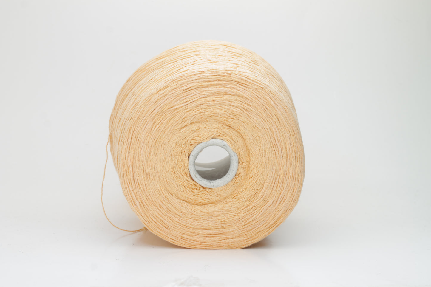 Close-up shot of a vibrant Muskemelon colored silk bourette yarn, showcasing its fluffy texture and intricate ply twist, with subtle sheen and depth.