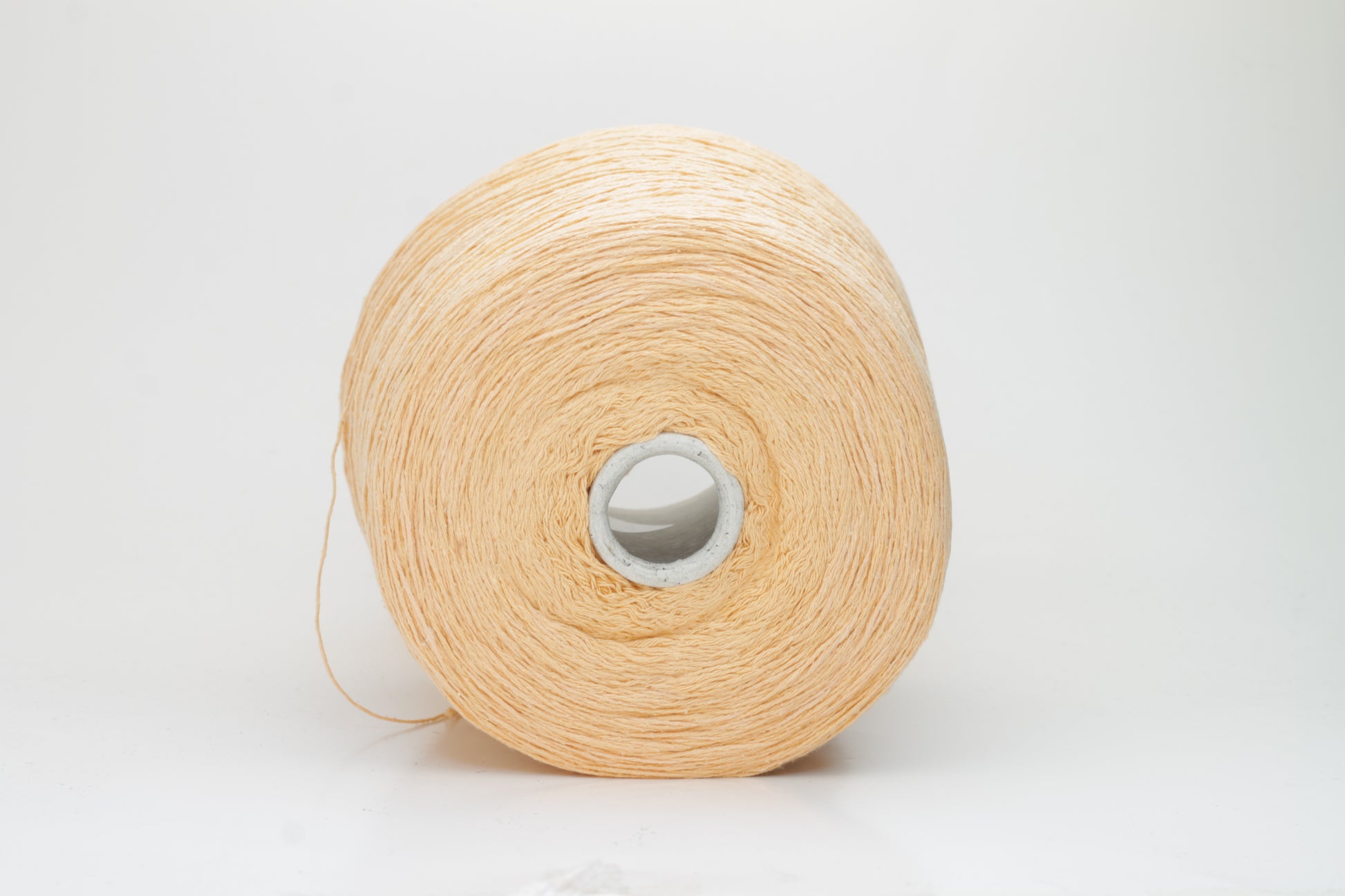 Close-up shot of a vibrant Muskemelon colored silk bourette yarn, showcasing its fluffy texture and intricate ply twist, with subtle sheen and depth.