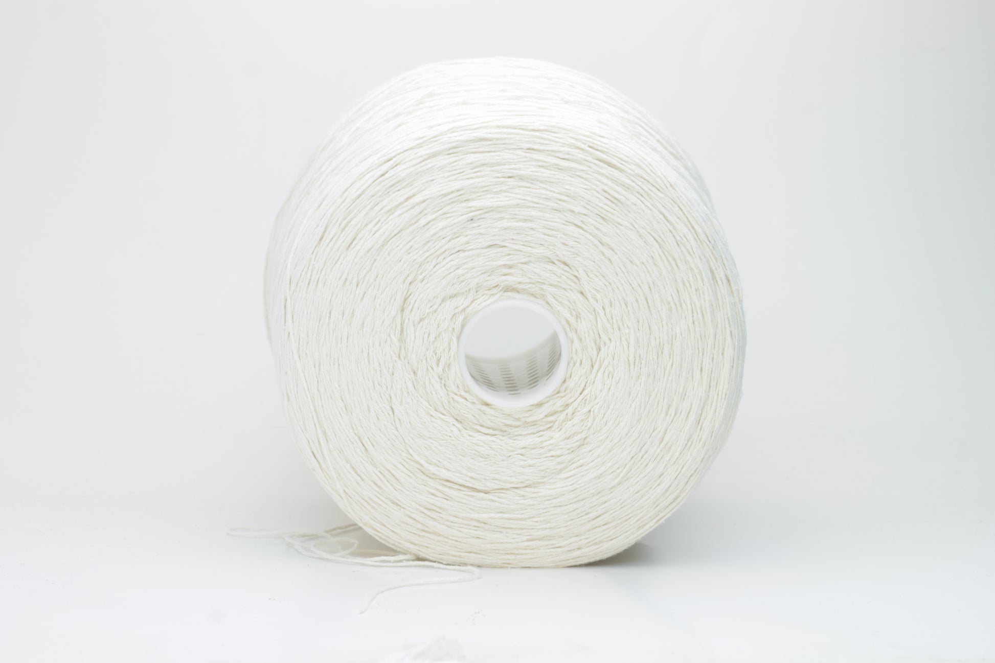 Close-up shot showcasing the fluffy, lustrous sheen of white silk bourette yarn in a single ply twist. The thread structure is clearly visible with subtle variations in color depth.
