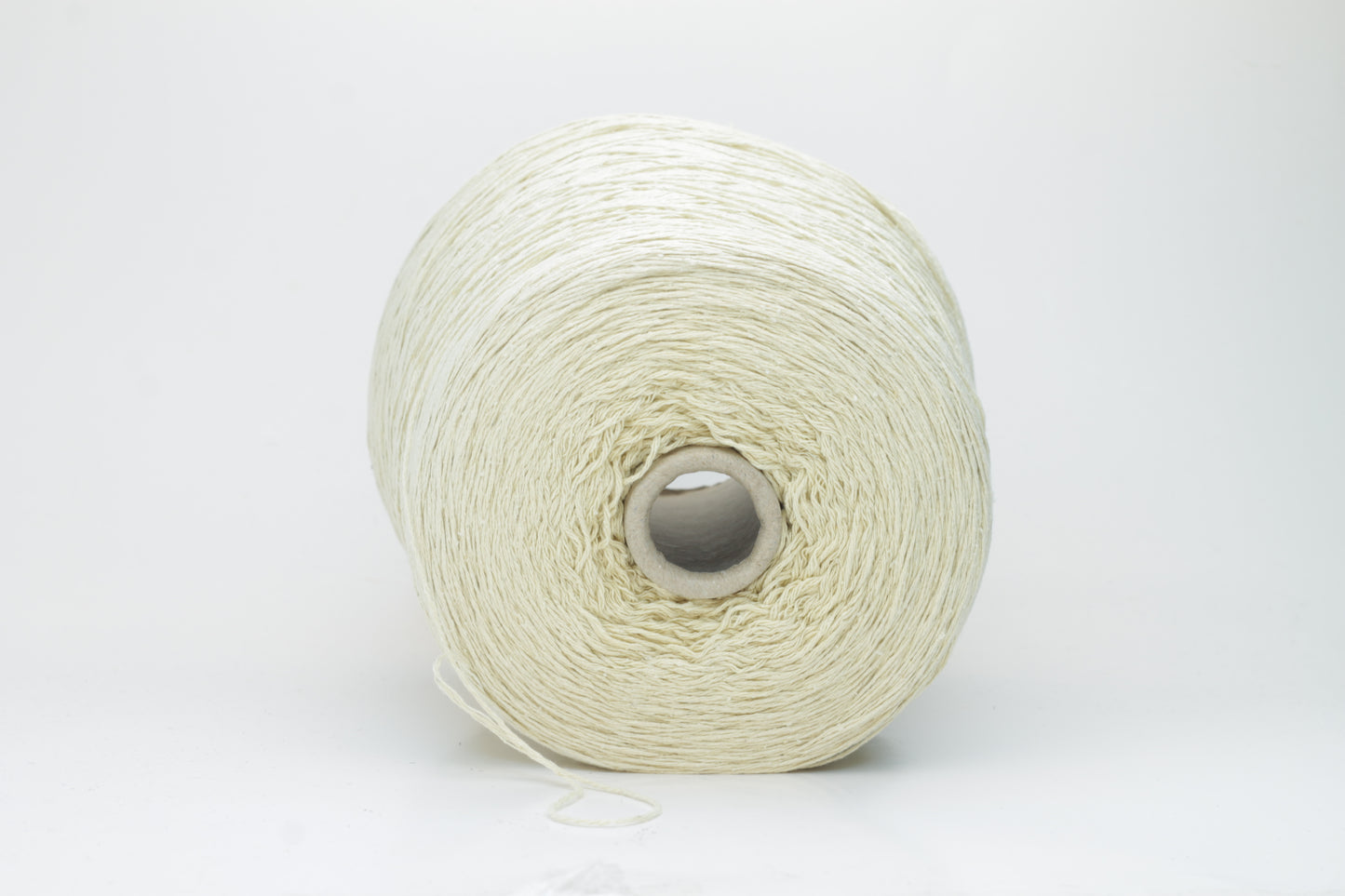 Close-up of creamy 'Giallino' Silk Bourette yarn, showcasing its incredibly fine ply twist and subtle sheen. The yarn has a smooth, almost liquid texture with abundant fluffiness.
