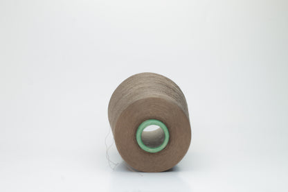Finely spun, single-ply silk yarn in a deep, rich cacao brown, exhibiting a smooth, tight twist and brilliant, natural sheen.