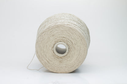 Close-up of a skein of natural beige 100% silk bourette yarn, showing its characteristic slubby, textured, slightly uneven threads.
