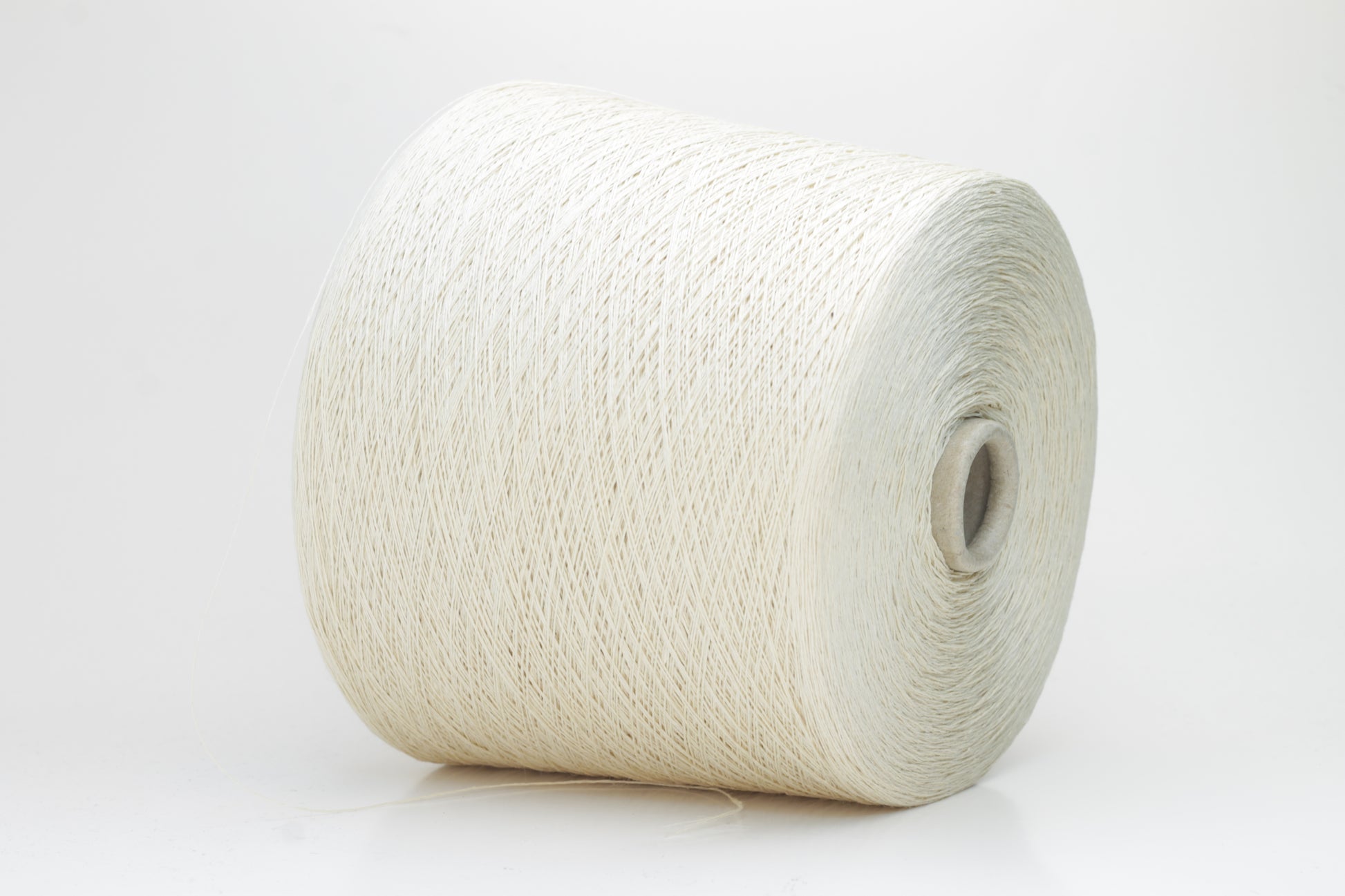 A soft light beige three-ply linen yarn, tightly twisted with a subtle natural sheen, presented in a neatly wound skein, showcasing its crisp, cool texture.