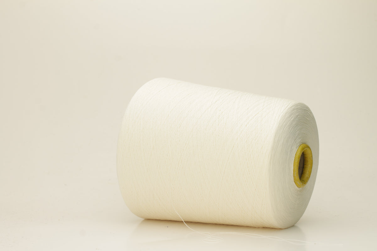 Close-up of pristine white, finely twisted silk yarn, showcasing its luminous sheen and smooth, consistent texture. The individual plies are barely discernible due to its delicate, high-count spin, reflecting light beautifully.