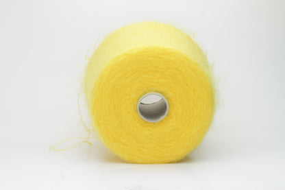 Close-up shot of vibrant yellow SuperKidMohair yarn showing a tight ply twist and soft, fluffy texture. The fibers exhibit a subtle sheen with excellent color depth.