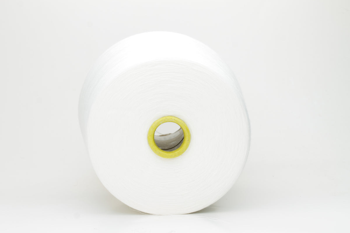 Close-up of a tightly wound, pure white skein of Loro Piana combed cotton yarn. It has a smooth, uniform texture and a subtle, elegant sheen.
