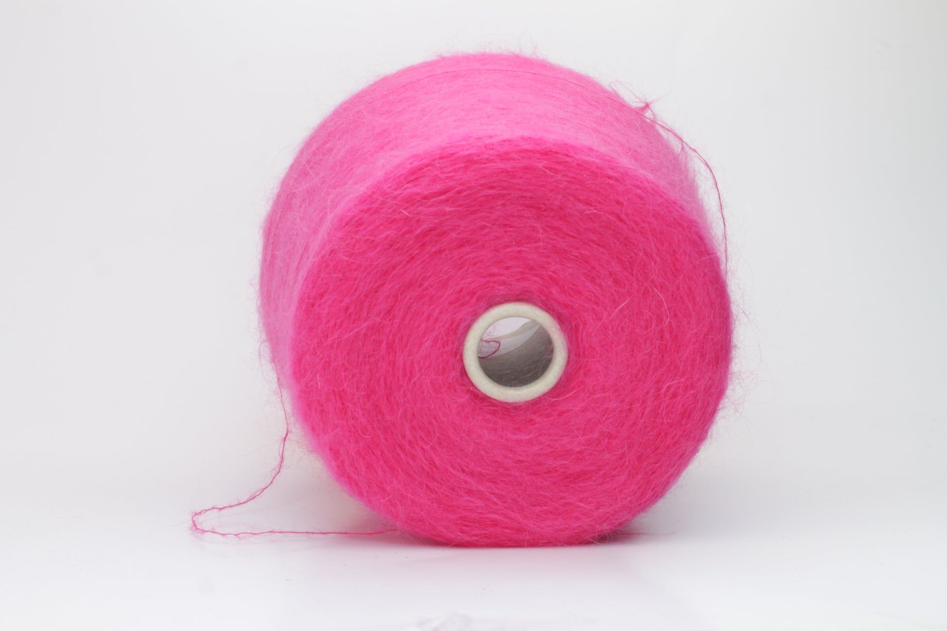 Close-up view of SuperKidMohair yarn in Fuxia, showcasing its fluffy texture and slightly twisted ply structure with subtle sheen.