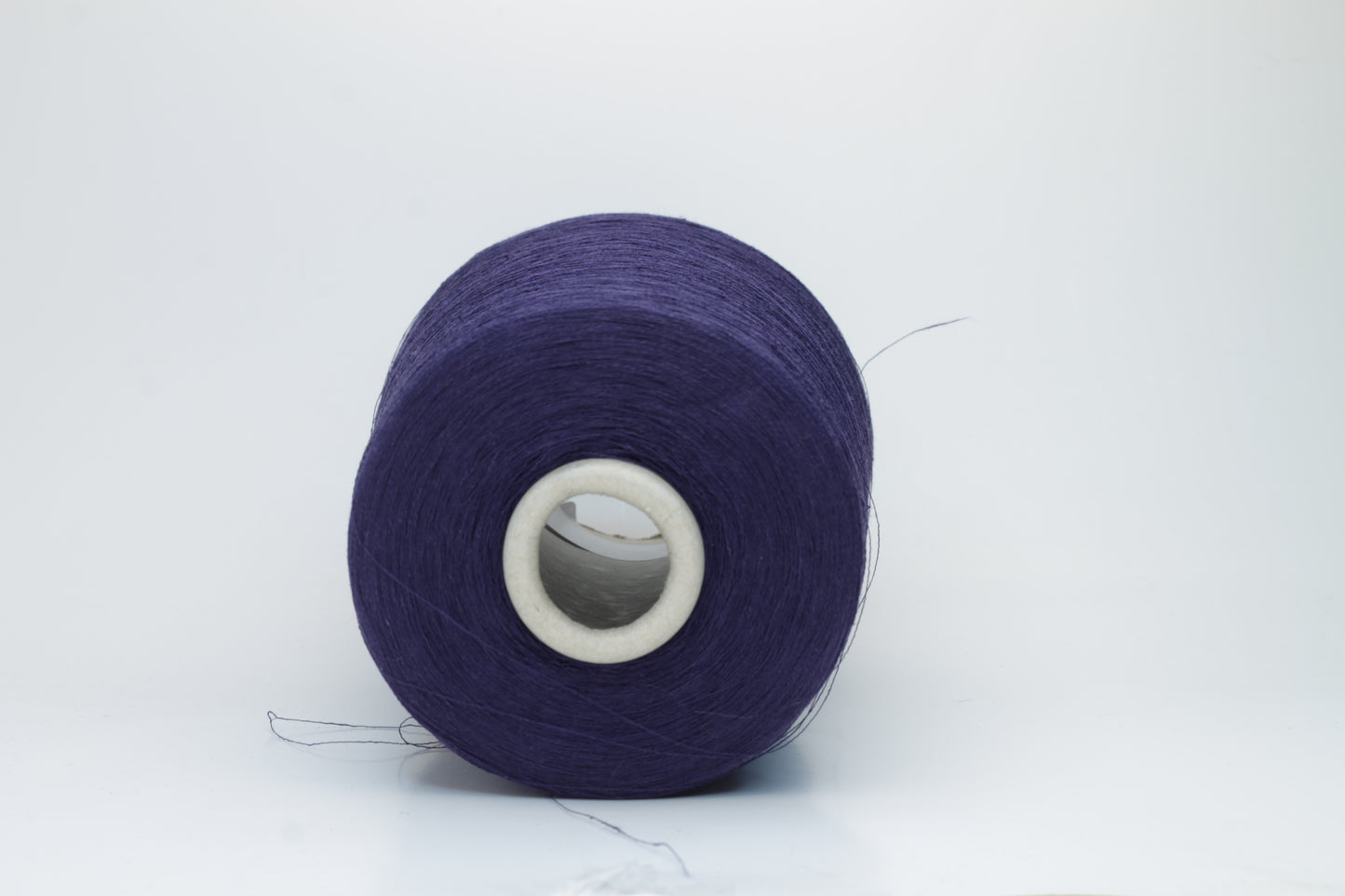 Close-up of a smooth, single-ply navy linen blend yarn, with a fine, crisp texture and subtle, natural sheen.