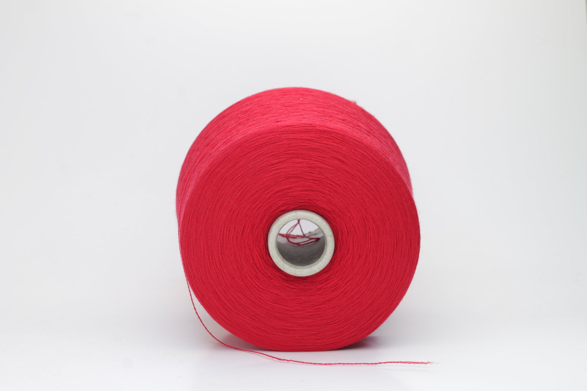 Close-up of luxurious Red Merino wool yarn, two-ply twist with a soft, subtle sheen, and fine, consistent thread structure.