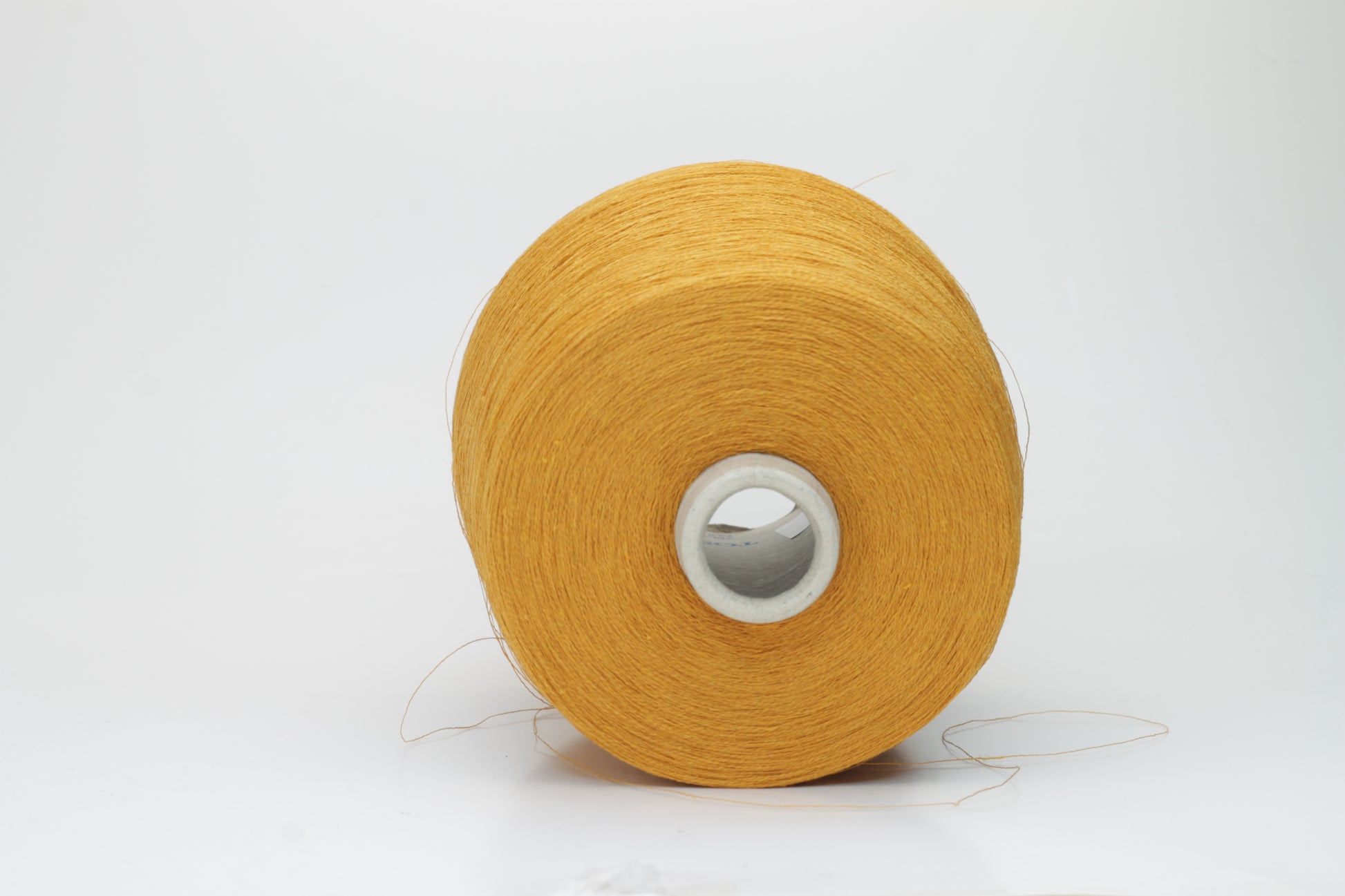 Close-up of a finely spun, vibrant orange yarn with a subtle, natural sheen. Its multi-filament structure shows a delicate twist, offering both crispness and soft resilience, suitable for textile artistry.