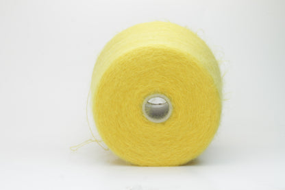 Close-up view of vibrant yellow SuperKidMohair yarn in a loose, fluffy ply twist. The yarn exhibits significant sheen and fluffiness, with distinct individual fibers visible.