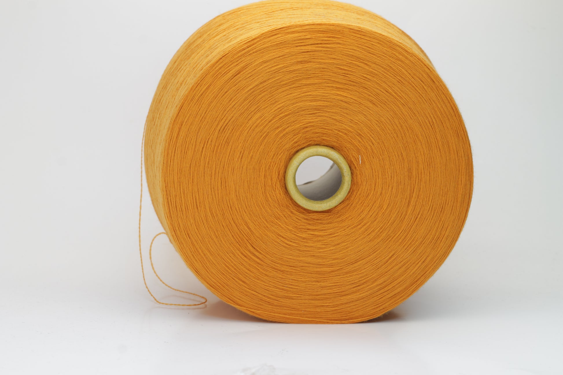 Close-up view of a vibrant orange Zegna Baruffa Merino yarn skein, showcasing the dense ply twist and smooth, fluffy texture with subtle sheen reflecting light.